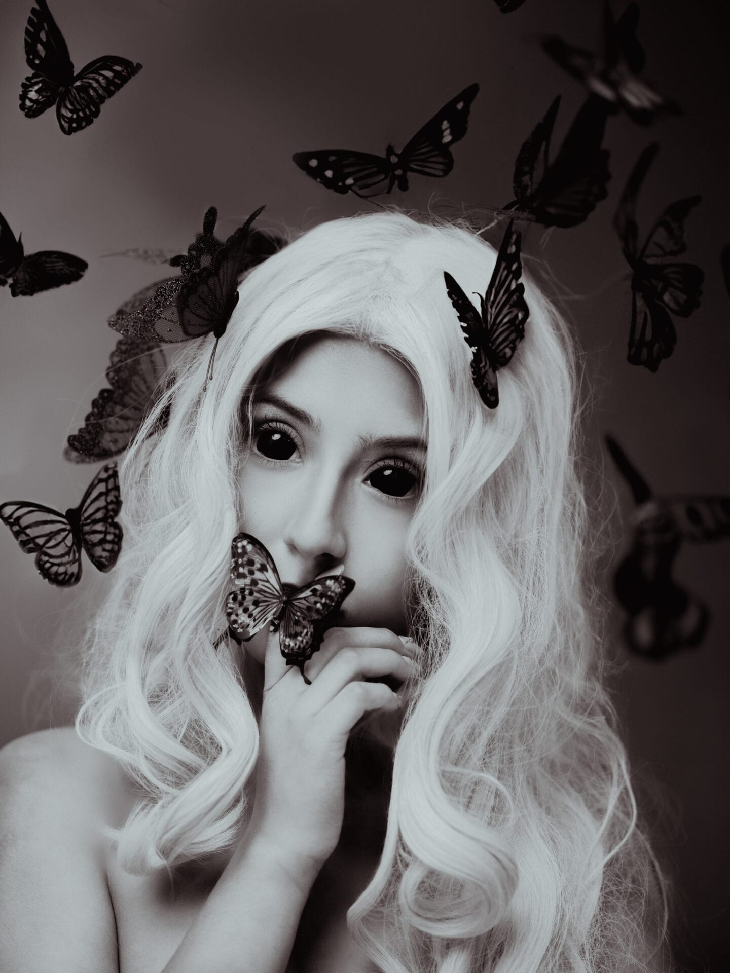 Fotografía artística en blanco y negro, representando el silencio y las palabras no dichas como mariposas que giran a nuestro alrededor.